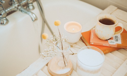 A bathtub set up with coffee and water as part of a home self-care routine. 